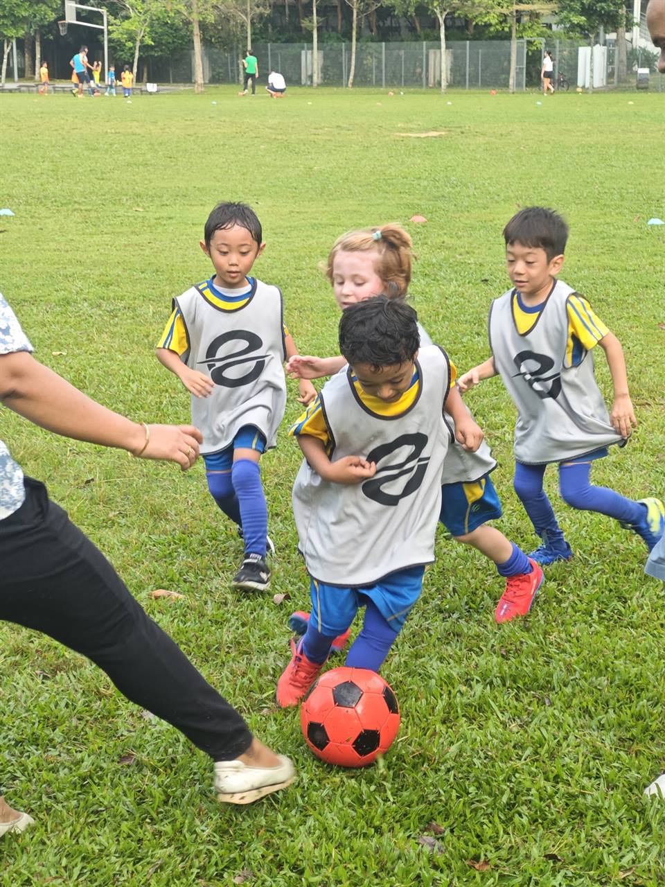 Young players in EPS bibs chasing the ball together