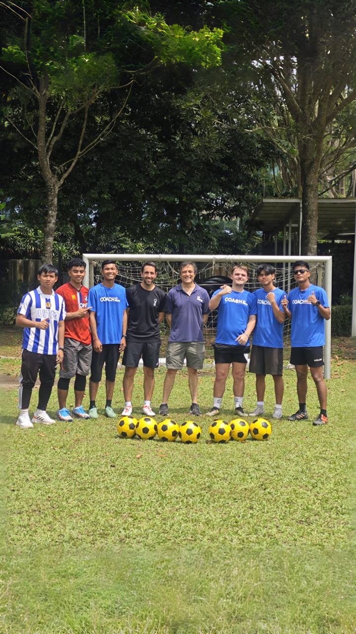 The EPS coaching team lined up in front of a goal with footballs