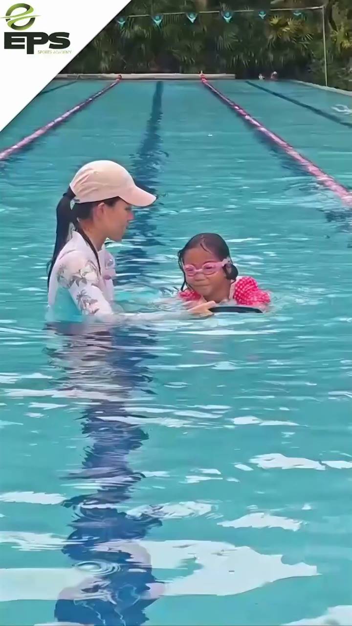 EPS coach guiding a young swimmer in the pool