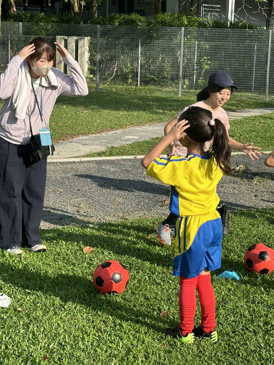 Toddler and parent playing football together
