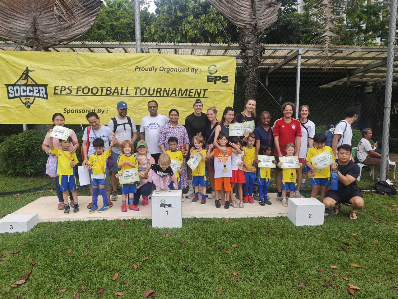Teams and coaches on the podium at the EPS Football Tournament